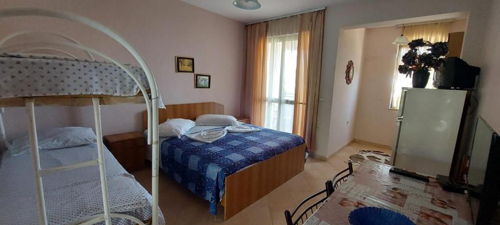 ein Schlafzimmer mit einem Bett und einem Etagenbett in der Unterkunft Villa Juvenilja in Durrës