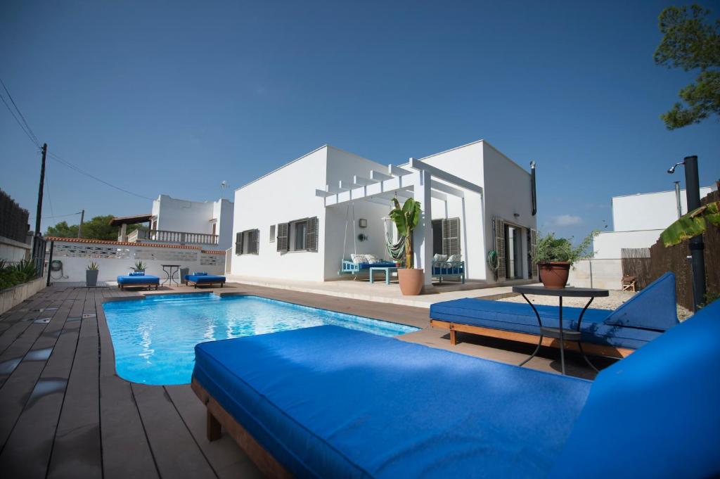 uma piscina com duas cadeiras azuis e uma casa em Ca n'Alorda Holiday Home Cala Llombards piscina, wifi, seguridad y relax em Santanyí