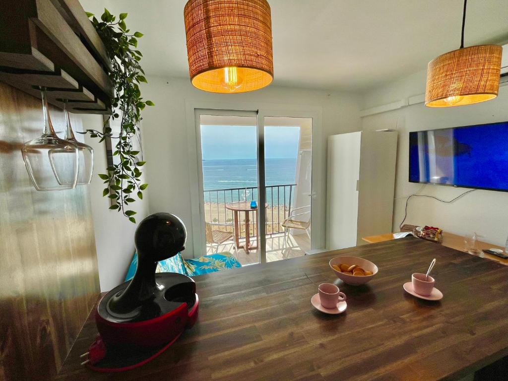een eetkamer met een tafel en uitzicht op de oceaan bij Apartamento vistas al Mar Aire acondicionado Wifi in Empuriabrava