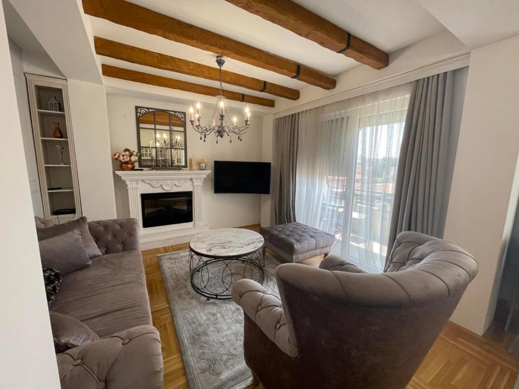 een woonkamer met banken en een tafel en een televisie bij Pupin Luxury Apartment in Ohrid