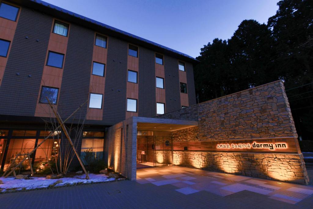 un edificio con un cartello che legge la locanda di cedro primaverile di Dormy Inn Express Fujisan Gotemba a Gotemba