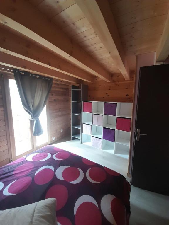 a bedroom with a large red and white bed and a window at Marmotte - Apartment near the cable car in La Grave in La Grave