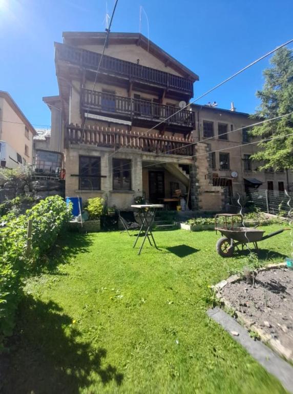 a large house with a yard in front of it at Marmotte - Apartment near the cable car in La Grave in La Grave