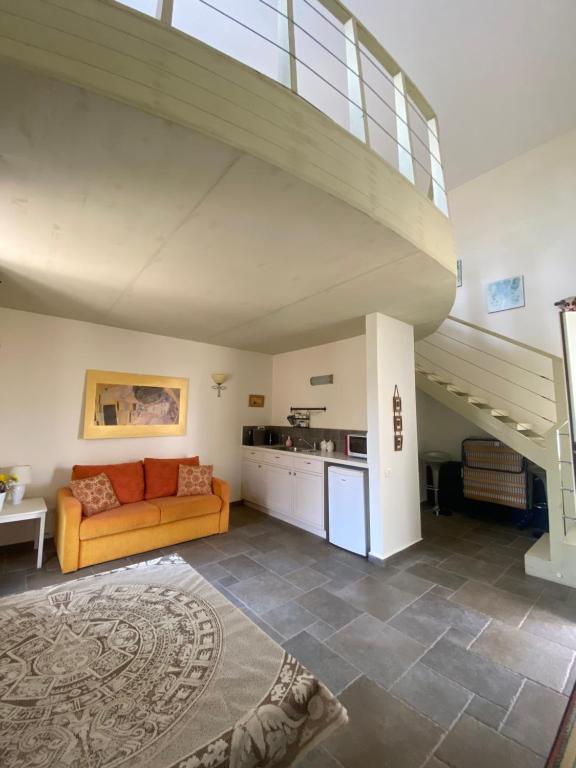uma sala de estar com um sofá e uma escada em אלרון - אירוח בגולן em Ani'am