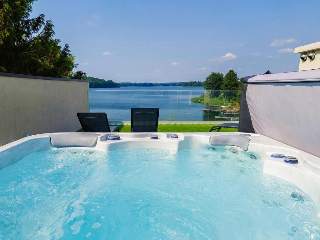 a hot tub with a view of the water at Herta House in Dorotowo