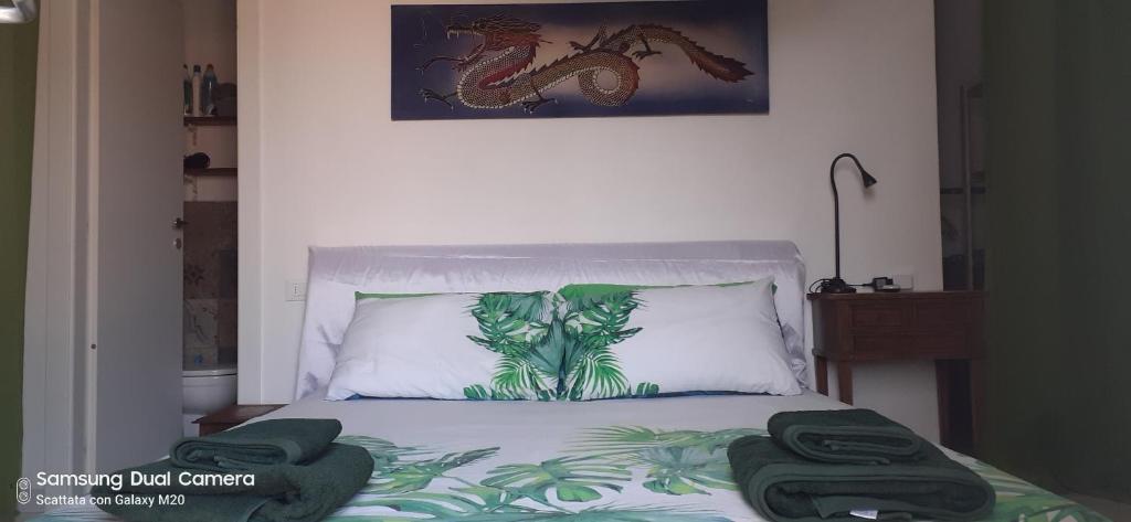 - une chambre avec un lit et 2 serviettes vertes dans l'établissement CAMERE private, à Porto Azzurro