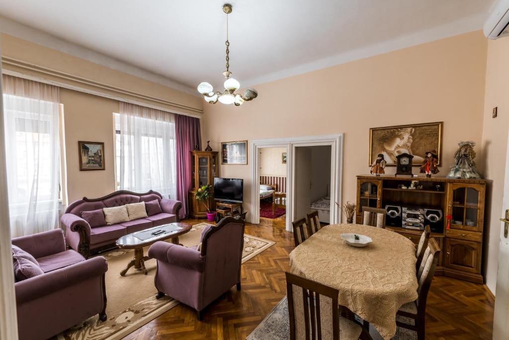 sala de estar con muebles de color púrpura y mesa en Apartment Panorama Central en Novi Sad