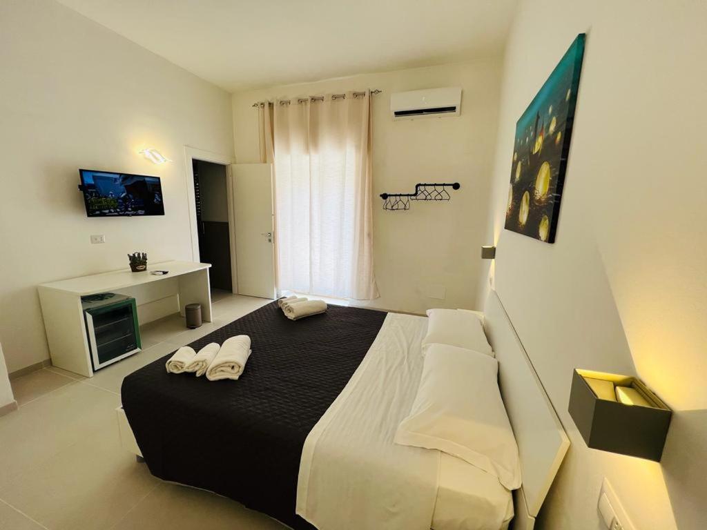 a bedroom with a large bed with two towels at Pirro’s rooms in Peschici