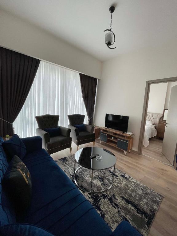 a living room with a blue couch and a table at Modern 1-bedroom apartment near Mall of Istanbul - 105 gunesli 10 in Istanbul