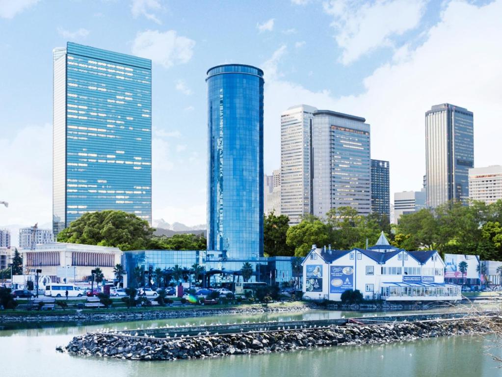 a city skyline with tall buildings and a river at Sky Tower Hotel in Batumi