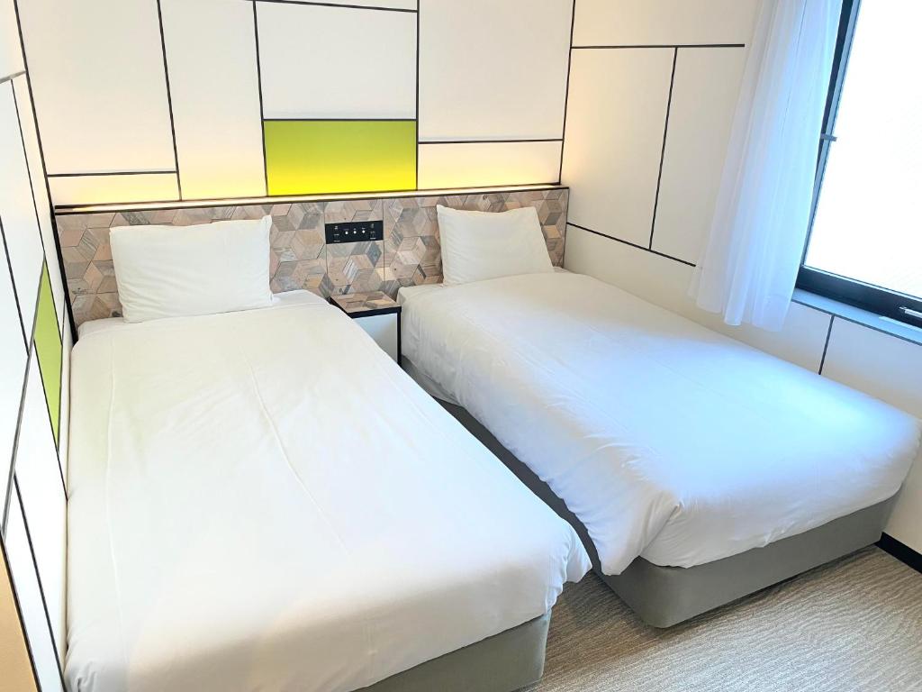 Postel nebo postele na pokoji v ubytování Henn na Hotel Osaka Shinsaibashi