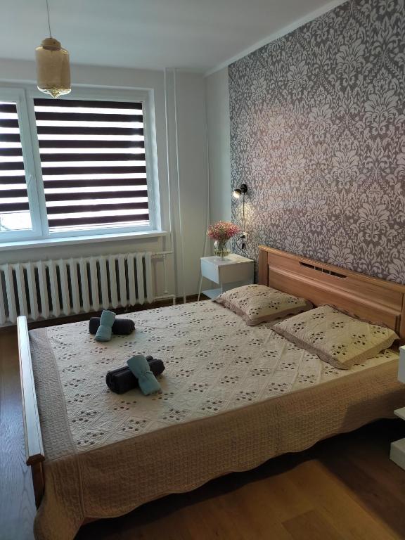 a bedroom with a bed with two teddy bears on it at 2-ju kambariu butas in Ignalina