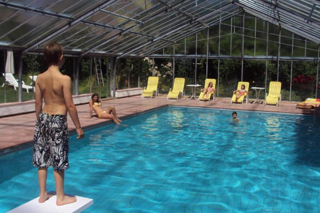 Ein Mann steht auf einem Block im Schwimmbad. in der Unterkunft Residence Klementhof 2 in Fiumes