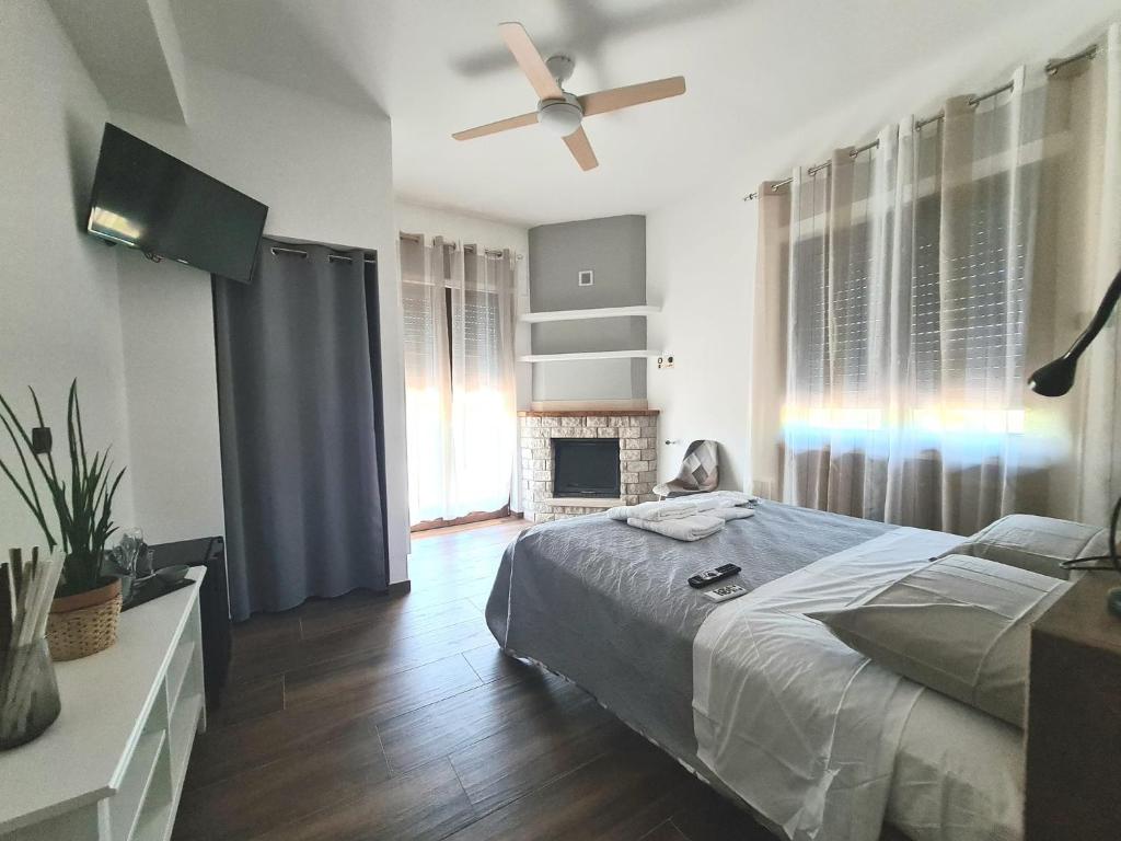 een slaapkamer met een bed en een plafondventilator bij Rossi&Nero Resort - Ristorante, B&B, Piscina, Sauna 