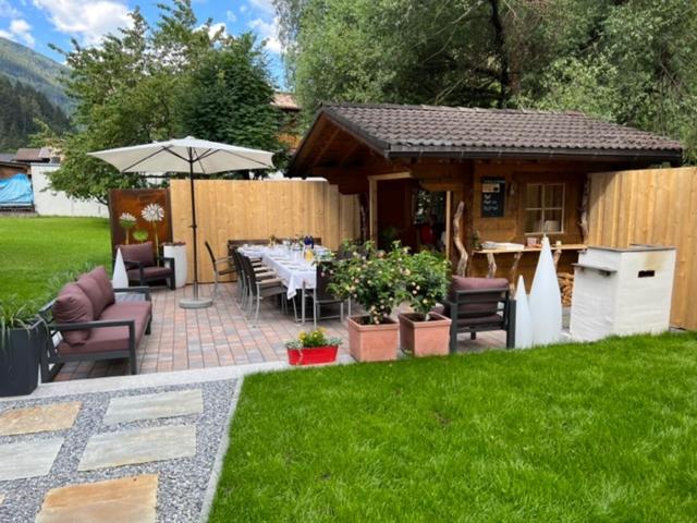 eine Terrasse mit einem Tisch und einem Sonnenschirm im Hof in der Unterkunft Apart Michaela in See
