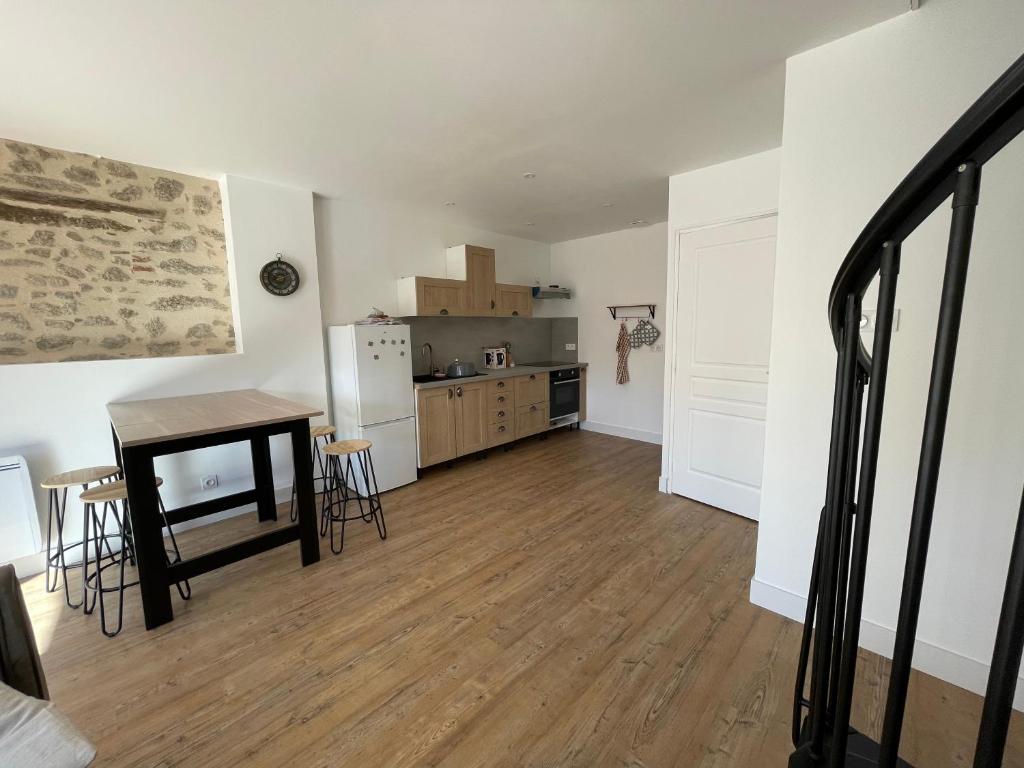 un salon avec une table et une cuisine dans l'établissement La grange, à Saint-Laurent-sur-Sèvre