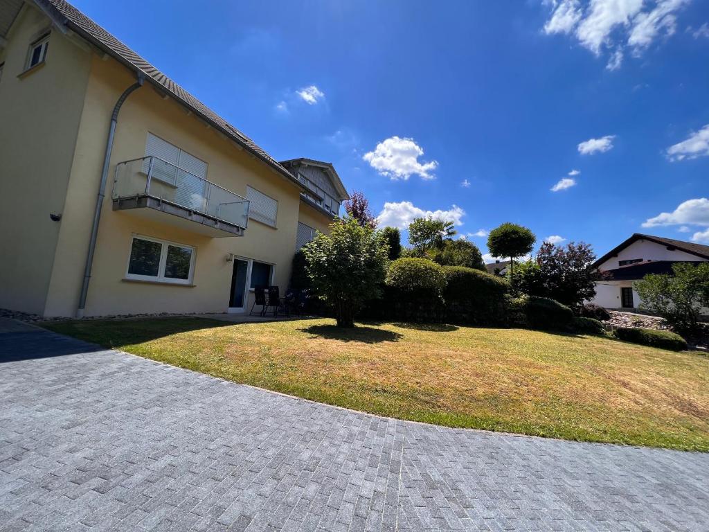 una casa con un patio de césped al lado de un edificio en Ferienwohnung zum Schauinslandweg, en Neunkirchen