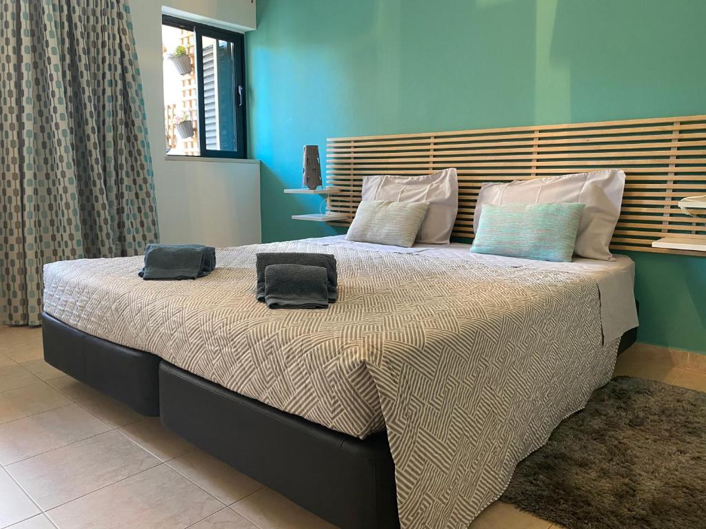 um quarto com uma cama grande com duas almofadas em Lodge Guesthouse em Lagos
