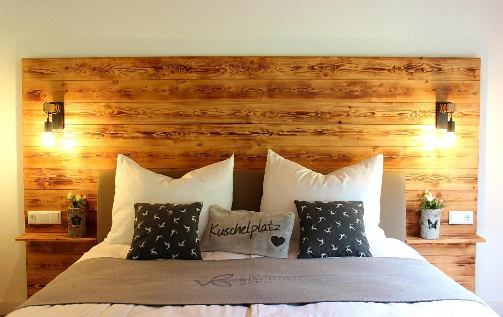 una camera da letto con letto, testiera e cuscini in legno di Villa Bischofsberg - Lärchen-Wellness Apartment a Windischgarsten
