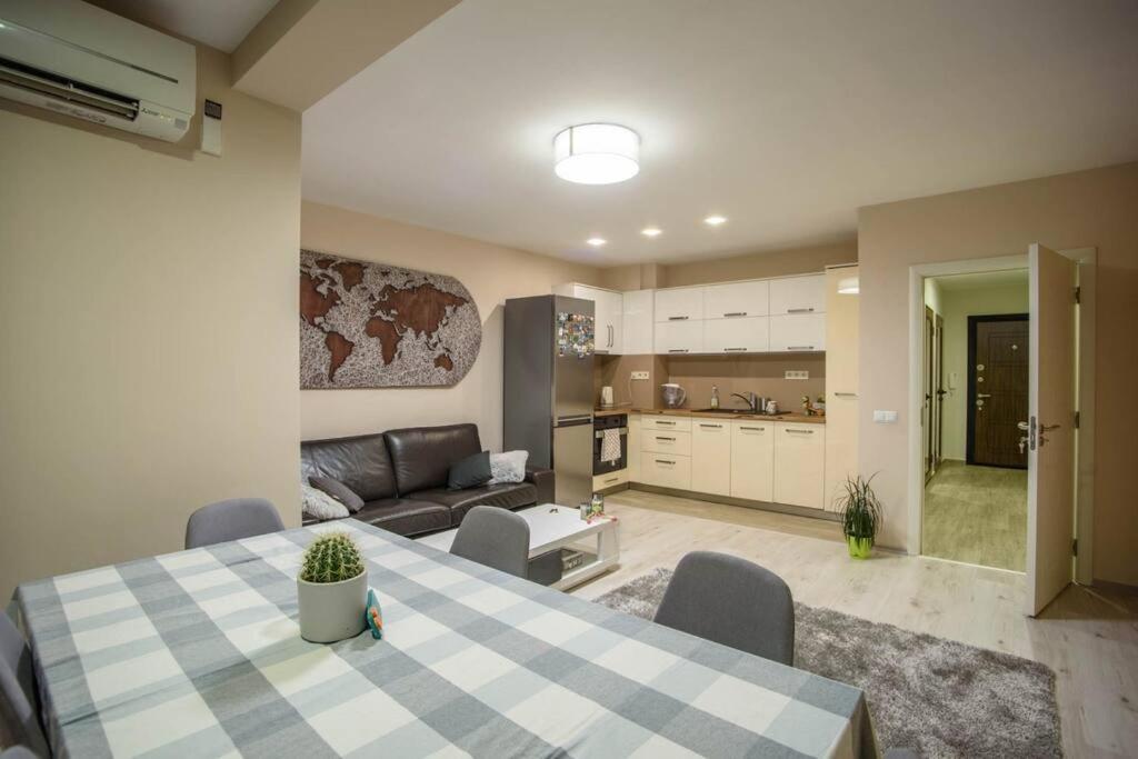 uma cozinha e sala de estar com uma mesa e um sofá em Sunny Spacious Apartment in a Great Location em Kazanlŭk