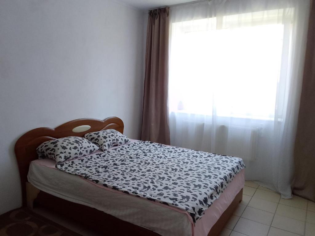 a bed in a room with a window and a bed sidx sidx sidx at Apartment Mlynivs'ka 29 A in Rivne