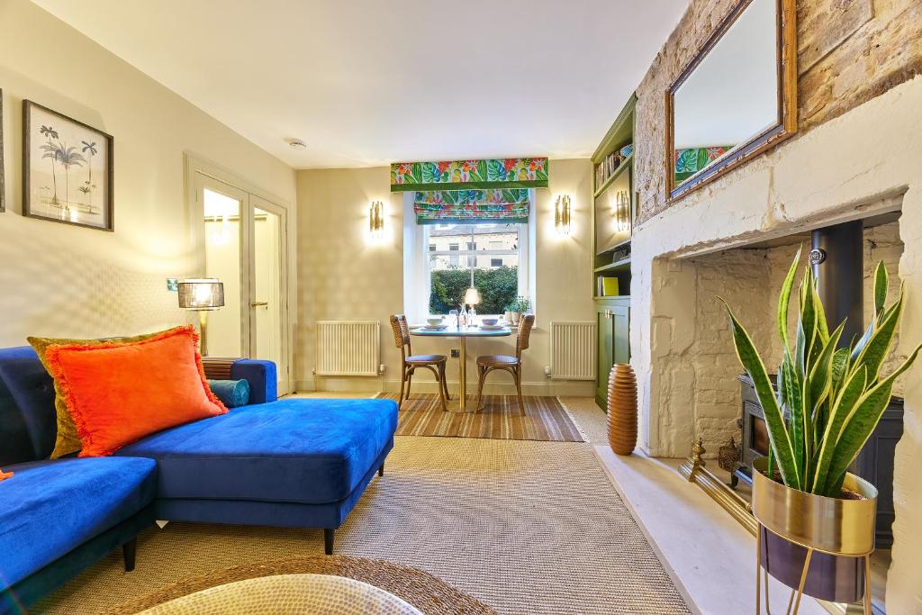 ein Wohnzimmer mit einer blauen Couch und einem Kamin in der Unterkunft Cinnabar Romantic Hideaway on Historic Walls in Berwick-Upon-Tweed