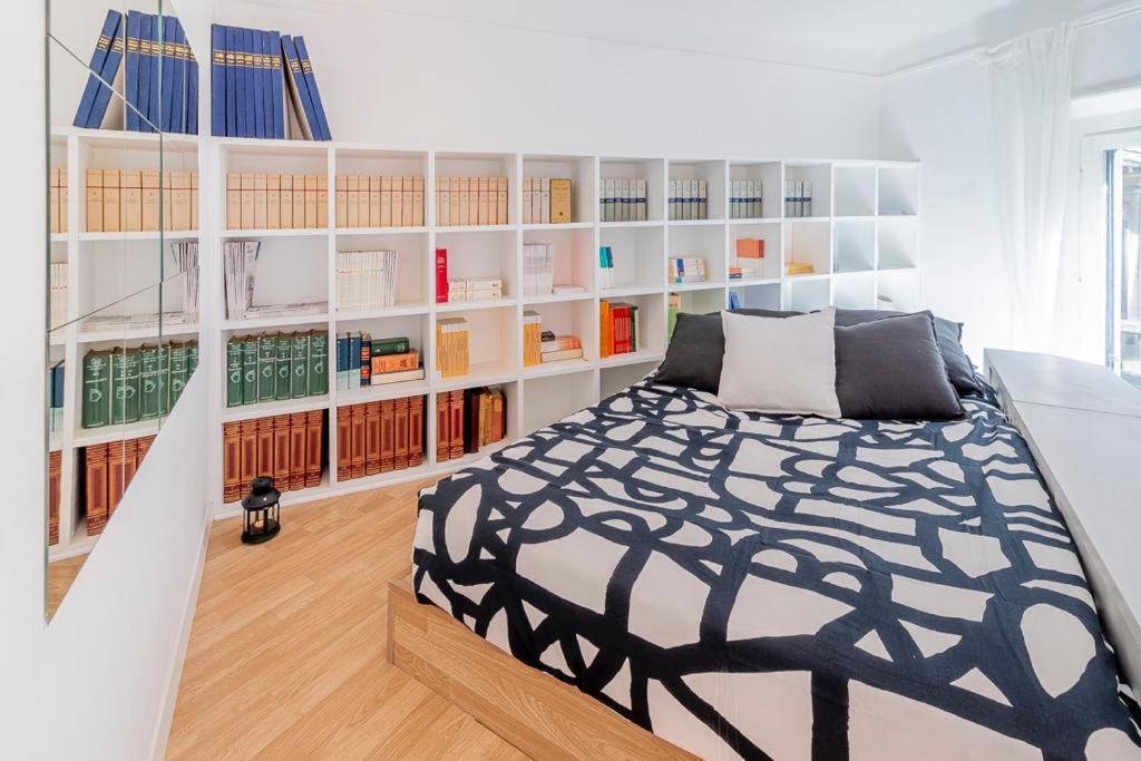 um quarto com uma cama em preto e branco e estantes de livros em Italianway - Cavallotti 17 em Milão