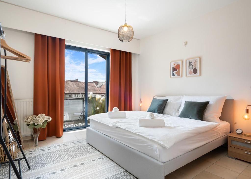 1 dormitorio con cama grande y ventana grande en City apartment 3 BEDROOM, KITCHEN, WIFI, WORKSPACE, COFFEE, Central, en Hasselt