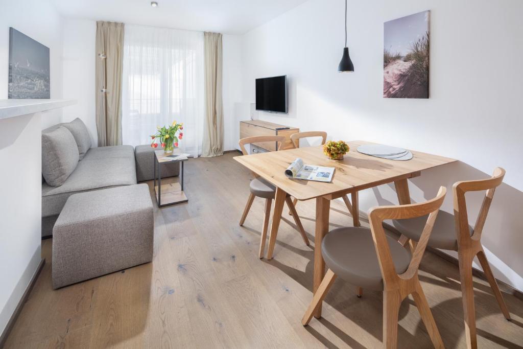 een woonkamer met een tafel en een bank bij Friesenhuus Friesenhuus Norderney, Whg 02 in Norderney