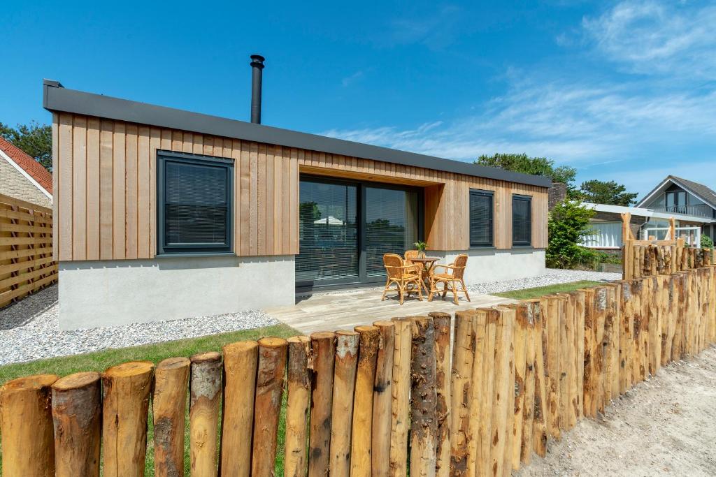 een huis met een houten hek ervoor bij Previnaireweg 5 Callantsoog in Callantsoog