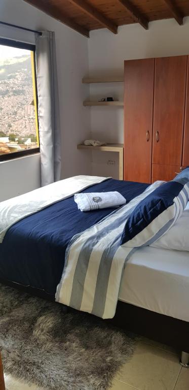 1 dormitorio con 1 cama grande y ventana en Wonderful house with views in Medellin-fiber optics, en Medellín