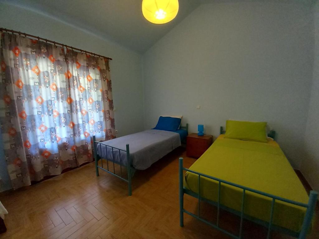 a bedroom with two beds and a window at Lazy Farm in Prásinon