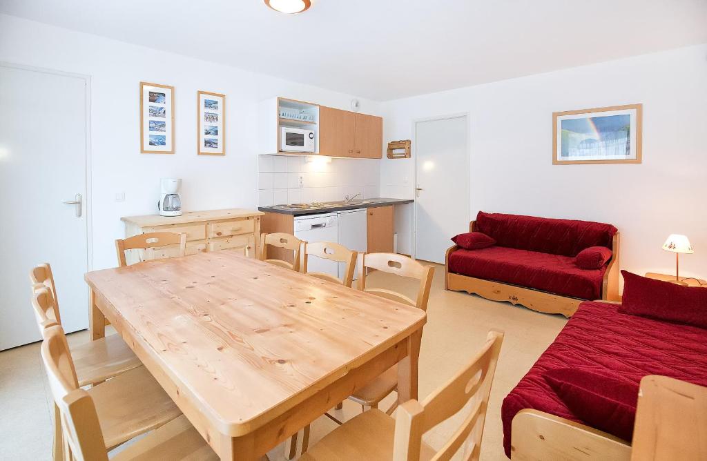 a kitchen and living room with a wooden table and chairs at Les Balcons PROCHE PARC NATIONAL VANOISE appartements 2 pieces 8 pers in Termignon