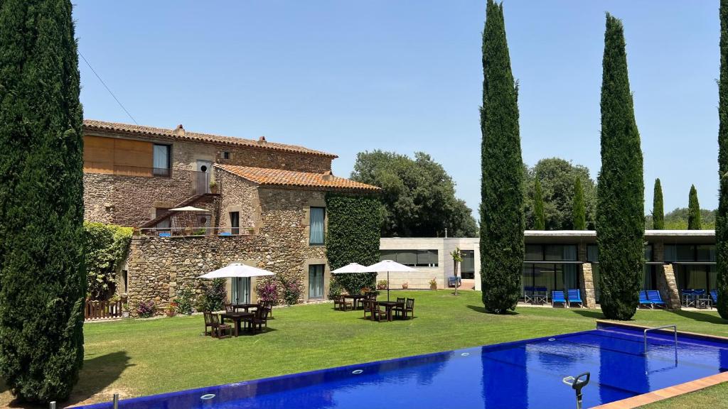 una villa con piscina di fronte a un edificio di Arcs De Monells - Adults Only a Monells