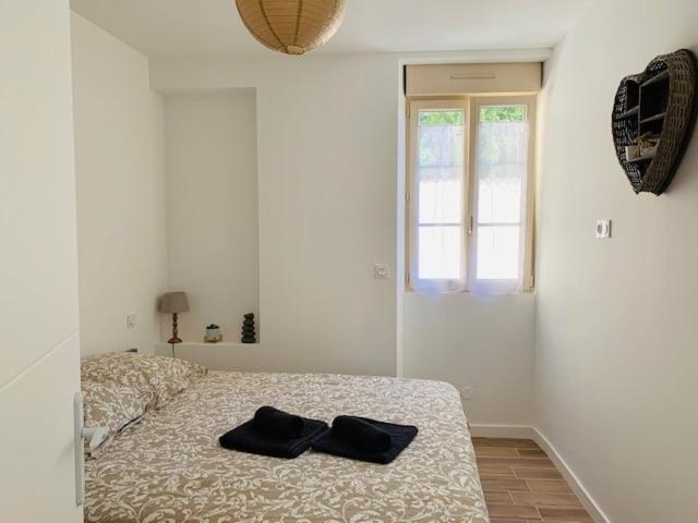 a bedroom with a bed with two black shoes on it at Centre ville (1) : superbe appartement climatisé in La Flèche