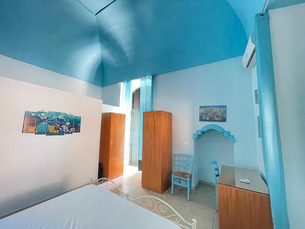 a blue room with a bed and a desk and a chair at GALLIPOLI DUESTANZE in Gallipoli