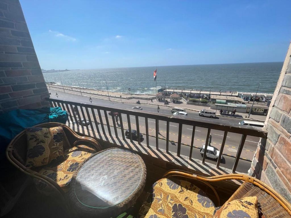 a balcony with a bench and a view of the beach at Amazing Sea View 2 bedroom apartment in Alexandria