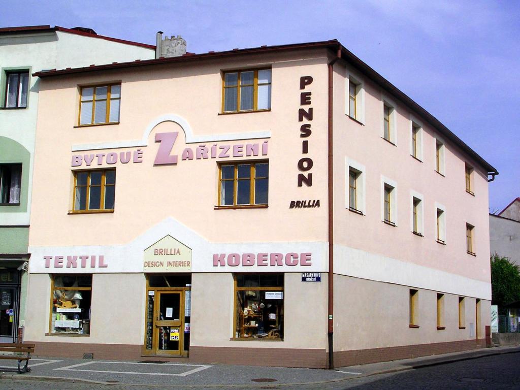 a large white building with a store front at Pension BRILLIA in Police nad Metují
