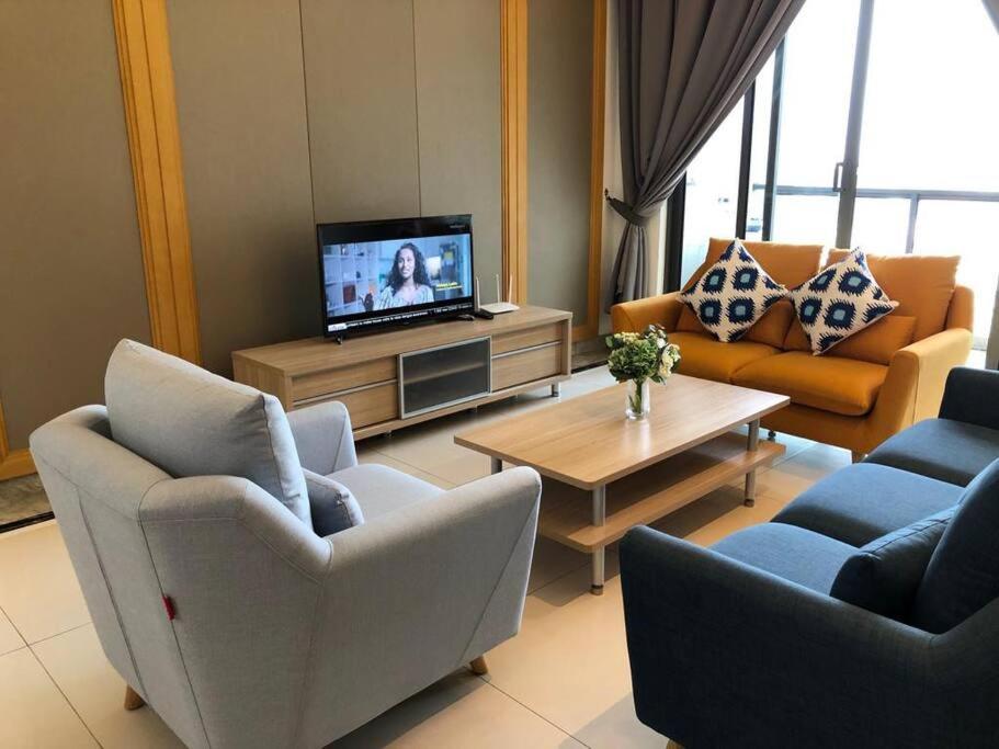 a living room with couches and a tv and a table at R&F Princess Cove by StayHere - 3BR in Johor Bahru