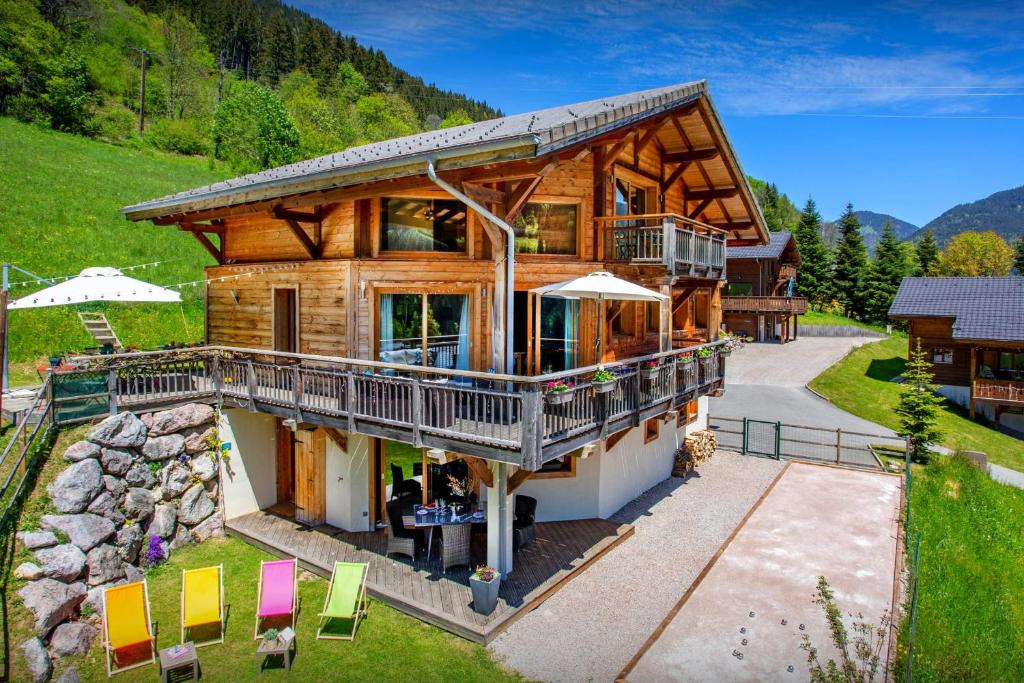 a large log cabin with a porch and balcony at Chalet Levant Blanc - OVO Network in Seytroux