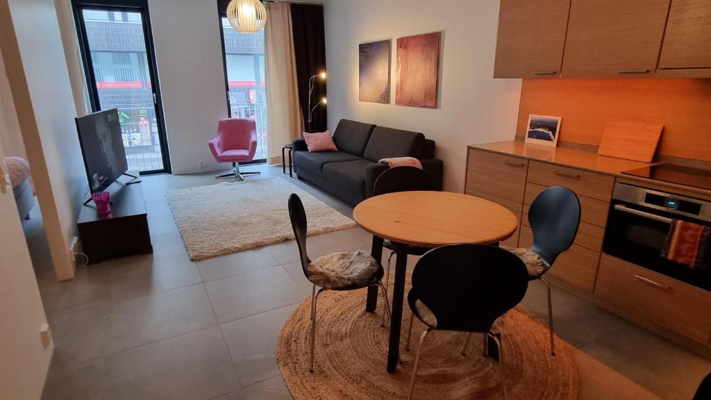 uma sala de estar com um sofá, uma mesa e cadeiras em Uusi, avara, saunallinen keskustakaksio em Tampere