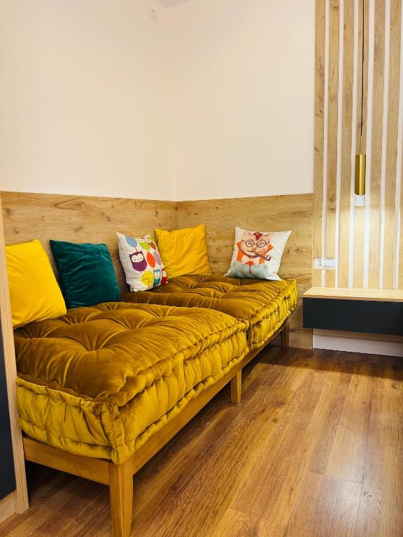 a couch with colorful pillows on it in a room at Chestnut Yard Villa in Tirana
