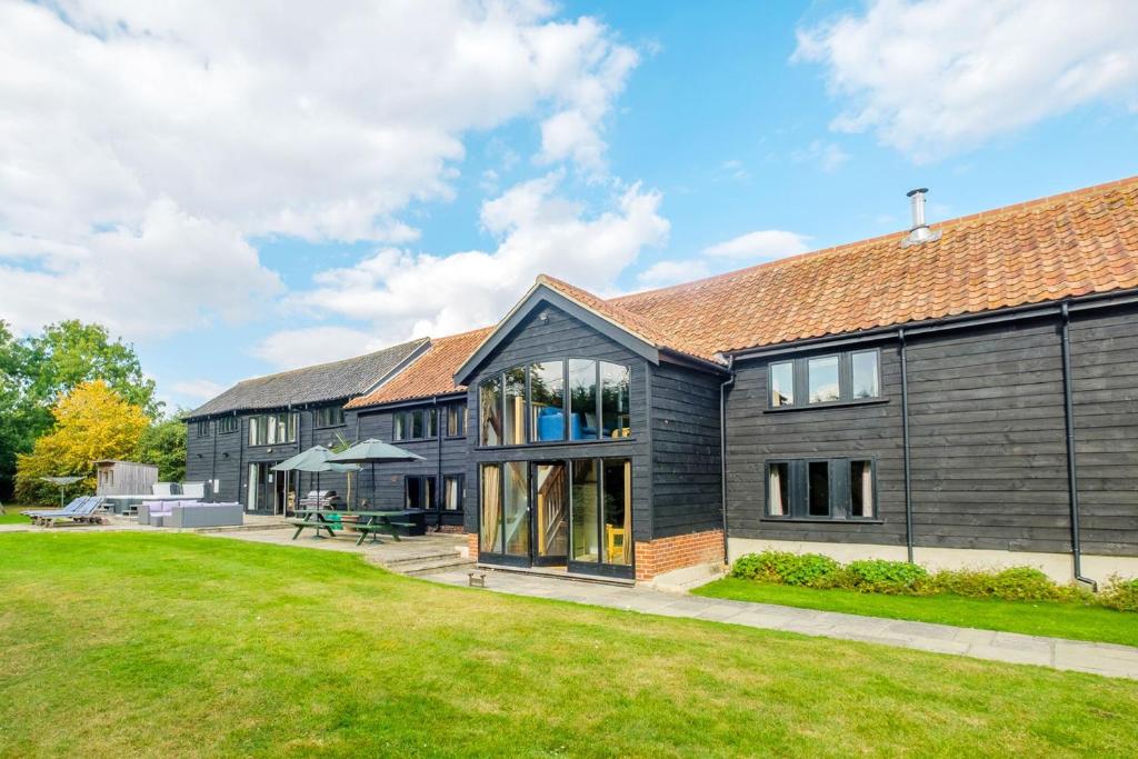 eine Außenansicht eines Hauses mit Hof in der Unterkunft Old Hall Barn - Aldeburgh Coastal Cottages in Darsham