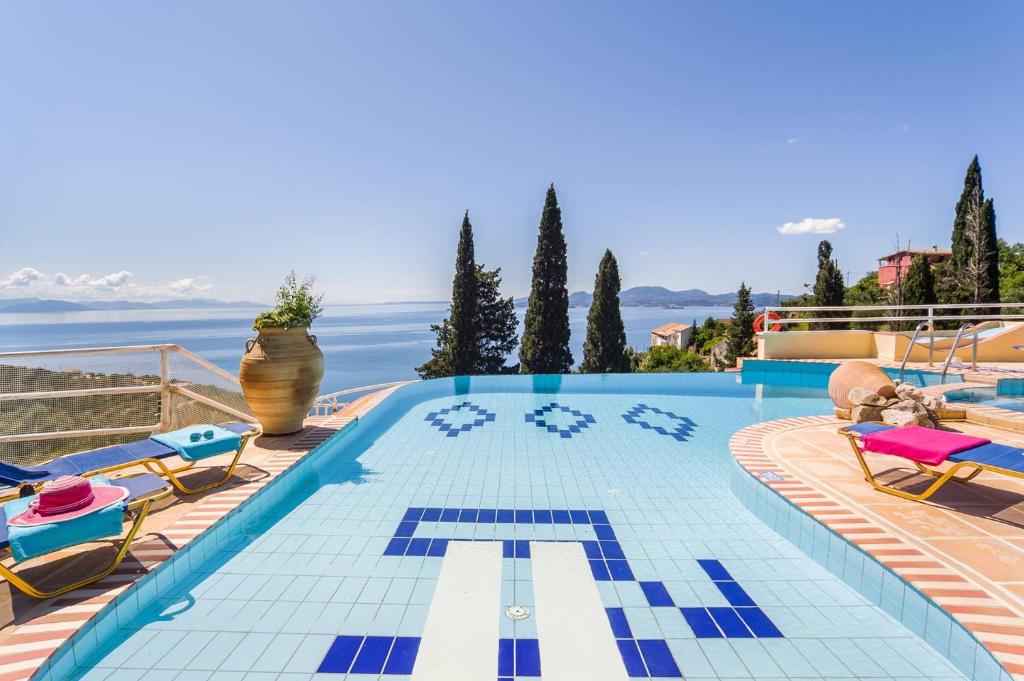een zwembad met blauwe en witte tegels op een huis bij Villa Vrysoulla by Villa Plus in Nisakion