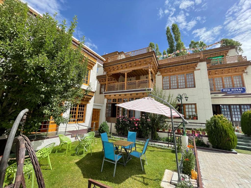 a patio with chairs and a table in front of a building at New Royal Guest House in Leh