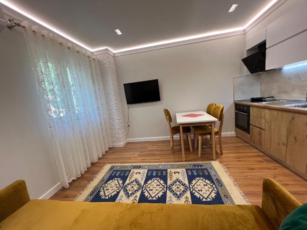 a living room with a table and a kitchen at Chestnut Yard Villa in Tirana