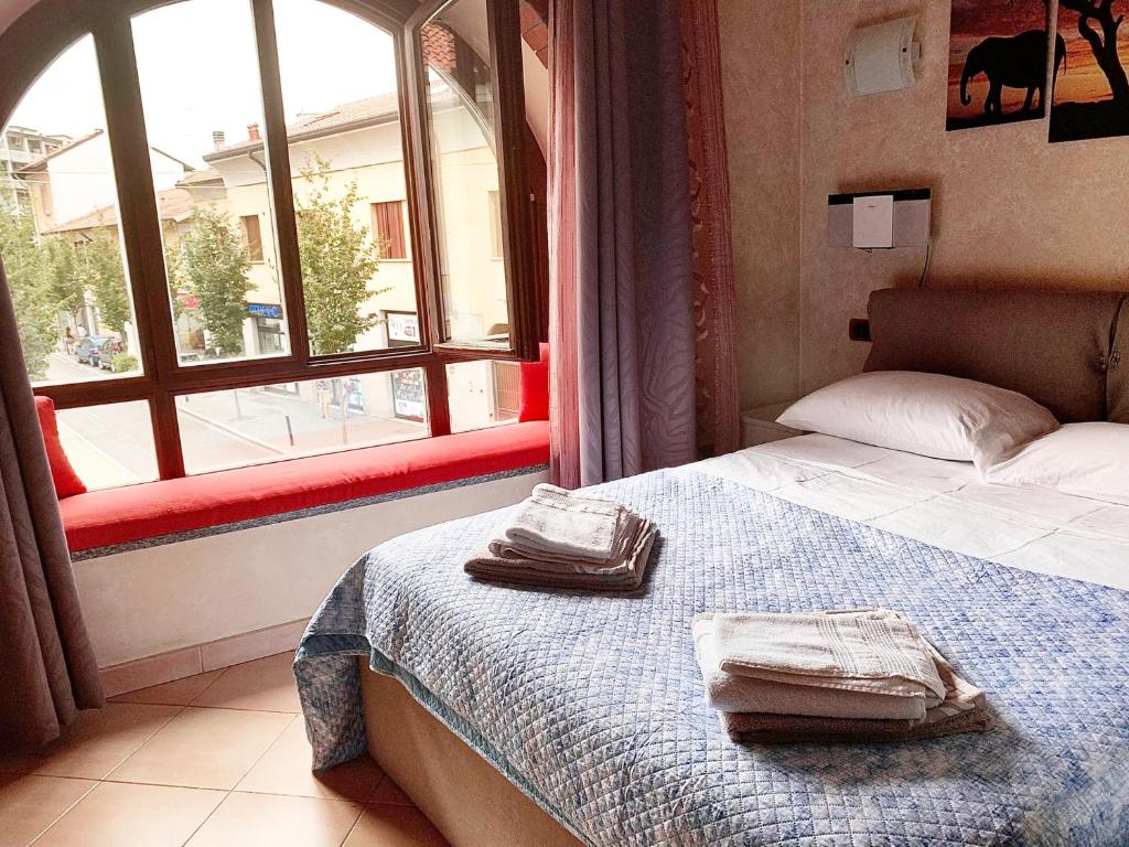 een slaapkamer met een bed en een raam met handdoeken erop bij B&B Corte del Centro in Novate Milanese