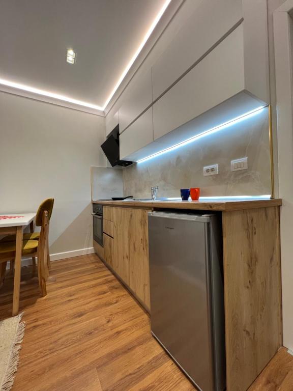 a kitchen with a stainless steel refrigerator and a table at Chestnut Yard Villa in Tirana