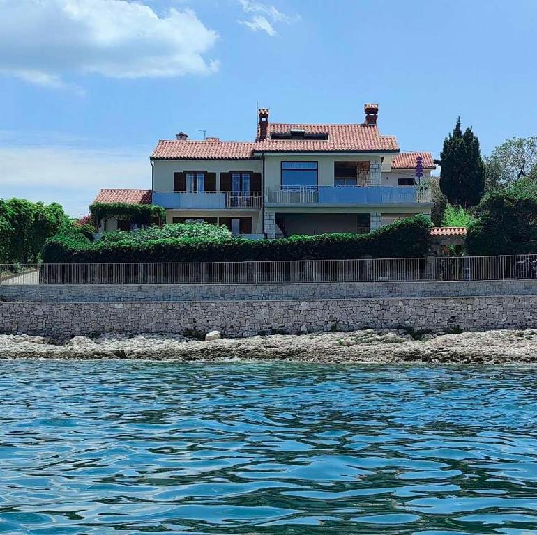 a house on the shore of a body of water at APARTMAJI PRI BOSI NOGI in Izola