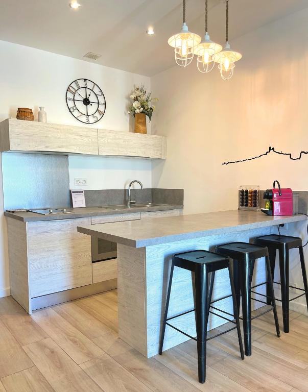 a kitchen with a large counter with stools around it at Les Appartements du Vieux Port in Marseille